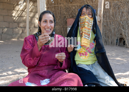 Bedouin mother and child having fun together while the mother is doing handcraft with beads Stock Photo