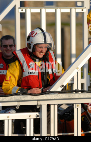 Female lifeboat volunteer laughing after practice drill Stock Photo