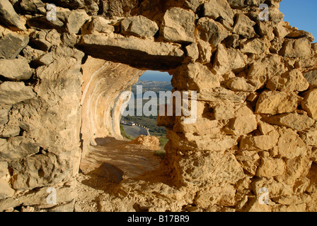 view towards Calpe through window in ruined wall from the Sierra Bernia area, Alicante Province, Comunidad Valenciana, Spain Stock Photo