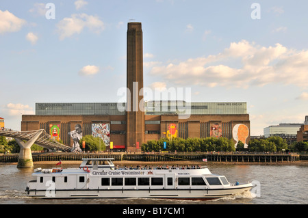 View of River Thames & Millennium Bridge with Tate Modern street art display on external wall of refurbished redundant power station London England UK Stock Photo