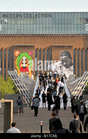 Street art display of graffiti at Tate Modern external brick walls on this revamped Bankside power station with people walking Millennium Bridge UK Stock Photo