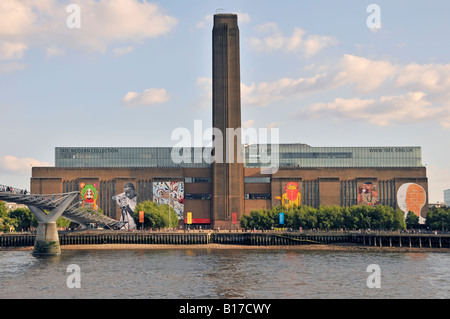 View across River Thames with Millennium Bridge & Tate Modern street art display on walls of refurbished redundant Bankside power station England UK Stock Photo
