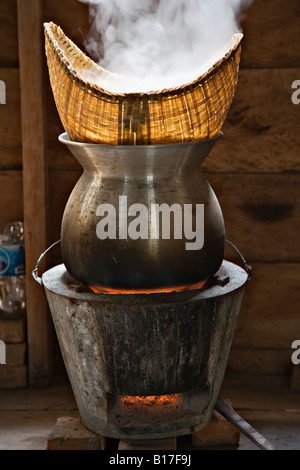 Sticky rice steaming in bamboo baskets over a taoloh at the