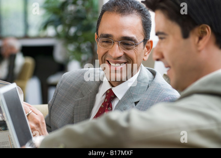 Hispanic businessmen looking at laptop Stock Photo