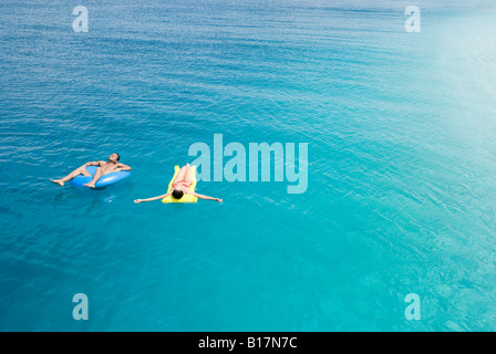 Multi-ethnic couple on floats in water Stock Photo