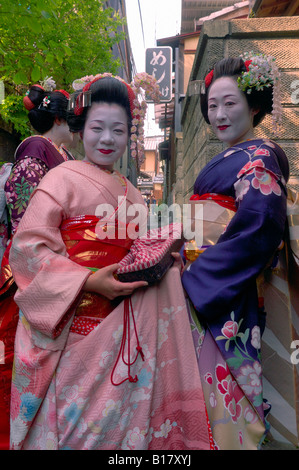 Asian women dressed up as geishas posing with a group of Japanese