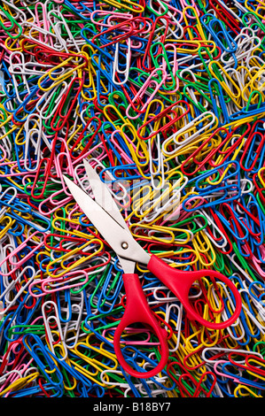 Red handled scissors on paperclips Stock Photo