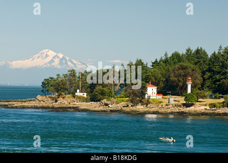 A fishing boat at the eastern entrance to Active Pass near Georgina Point on Mayne Island, with Mount Baker in the background, B Stock Photo