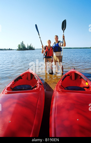 Couple with kayaks at Otter Falls Campground, Whiteshell Provincial Park, Manitoba, Canada. Stock Photo