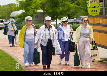 EVENTS Libertyville Illinois Four senior ladies with shopping bags walk to bus shuttle stop in parking lot Seniors Day