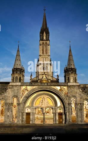 FRANCE, LOURDES. Morning sun rays falling on the church in the sanctuary in Lourdes France Stock Photo