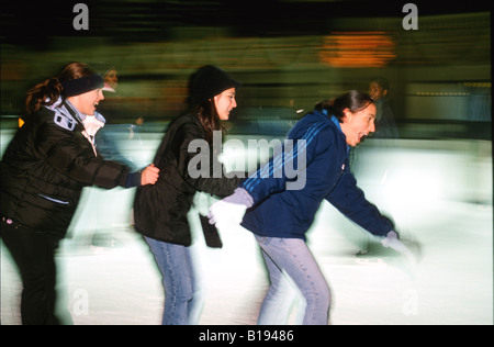 SKATING Chicago Illinois Ice skaters at Millennium Park ice rink winter fun on Michigan Avenue three girls Stock Photo