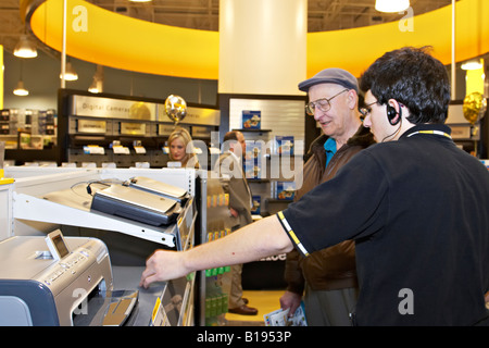 EVENTS Algonquin Illinois Salesman offer assistance to customer in OfficeMax retail store young man assist old man make purchase Stock Photo