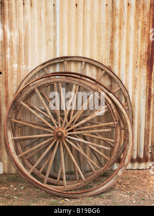 Old coach wheels leaning against a wall. Stock Photo