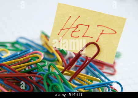 Paper clips and post it note with Help written on it - organisation / office / work concept Stock Photo
