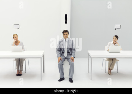 Man sitting in office with exclamation mark over his head, women on either side with blank word bubbles Stock Photo