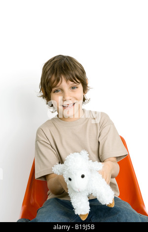 Boy holding plush toy lamb Stock Photo