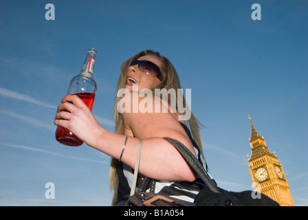 New Zealand woman with a wine bottle in front of Big Ben in Parliament Square during Waitangi Day Circle Line pub crawl Stock Photo