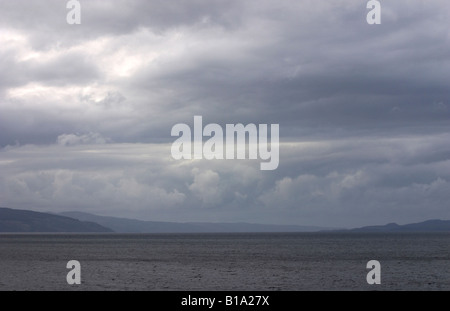 Heavy laden sky looking from the sannox coastline across the firth of clyde with the Isle of bute in the background Stock Photo