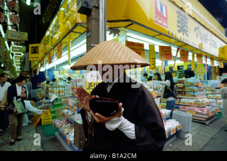 Japan, Tokyo, Asakusa, buddhist monk begging in front of a shop Stock Photo