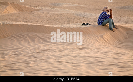 berber is sitting on the sand dune Sahara desert Tunis Stock Photo