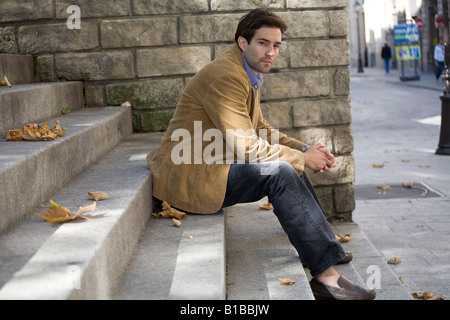 Young man sitting on steps in Paris Stock Photo