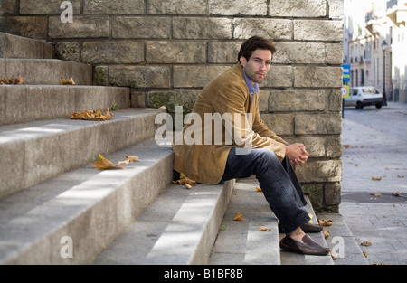 Young man sitting on steps in Paris Stock Photo