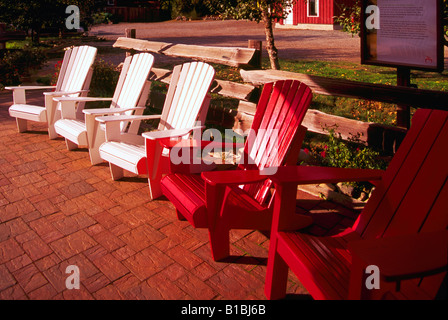 Three wooden Adirondack chairs painted in the primary ...