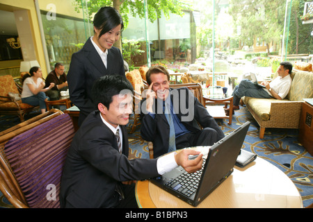 businesswoman and businessmen from different cultures using laptop in hotel Stock Photo