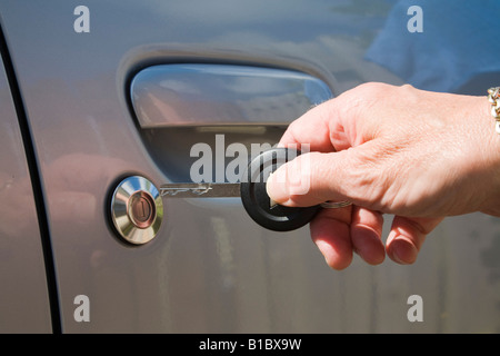 Britain UK Mature woman holding car key in hand by door lock Stock Photo