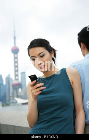 young woman using mobile phone at the Bund,Shanghai,China Stock Photo