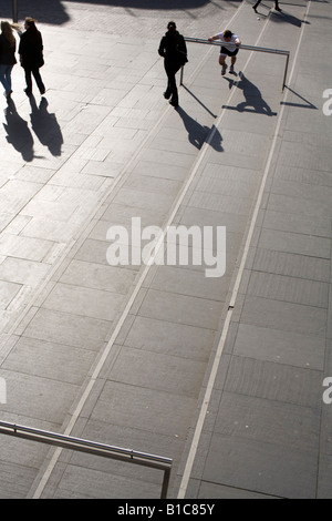 Man doing his exercises while people walk past. The South Bank, London, UK Stock Photo