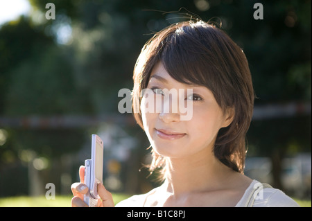 Young woman holding mobile phone Stock Photo