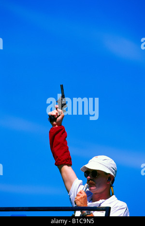Ready Set Go - Sports Official holding Starter Pistol at Starting Line of Track and Field Race Stock Photo