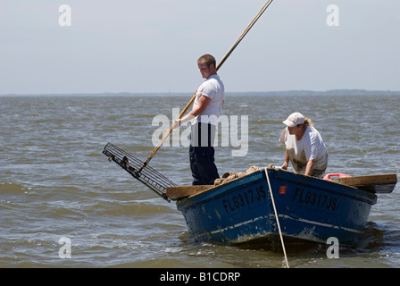 a working oyster tongers boat in Apalachicola Bay along North Florida panhandle coast Stock Photo