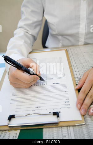 Young woman filling in sheet Stock Photo