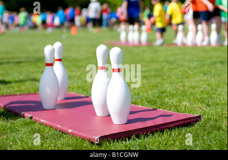 Bowling pins on a mat during children's game outside. Stock Photo
