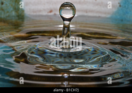 Water drop hitting surface of clear water Stock Photo