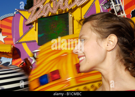 young woman in front of a carousel at the amusement park Wiener Prater, Austria, Vienna Stock Photo