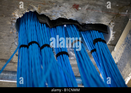 Data cables connecting two ajoining floors in a new office fit-out pass through a hole cut in the concrete florr/ceiling Stock Photo