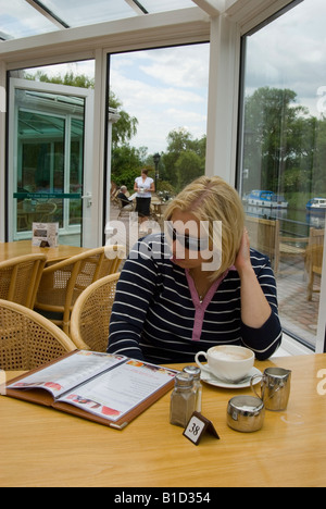 Woman Enjoying Coffee And Reading Menu At The Waveney Hotel Beccles,Suffolk,Uk Stock Photo