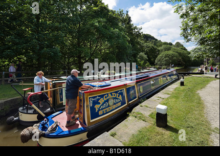 Narrowboats about to exit the lock gates on the Rochdale Canal, Hebden Bridge, Calder Valley, West Yorkshire, England Stock Photo