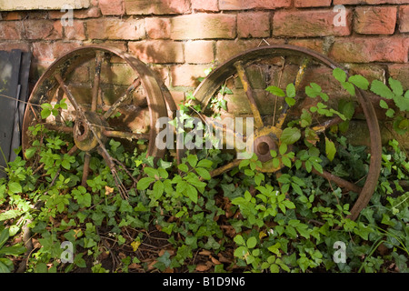 old cast iron wheels against wall Stock Photo