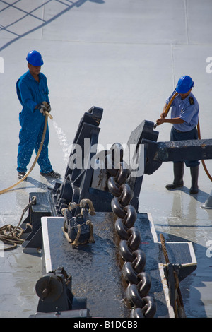 Washing the anchor chain as it is winched in on Cunard QE2 Stock Photo