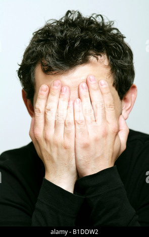 Man covering his face with his hands Stock Photo