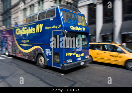 A City Sights NY double decker tour bus rolls down Broadway in Manhattan, NY Stock Photo