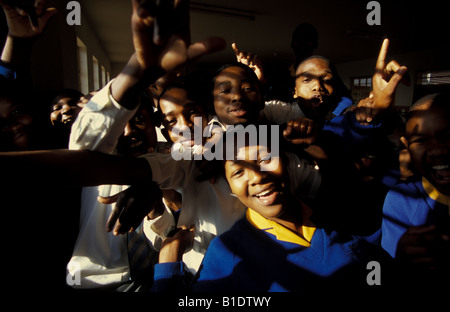 School kids in African township crowding round celebrating. Stock Photo