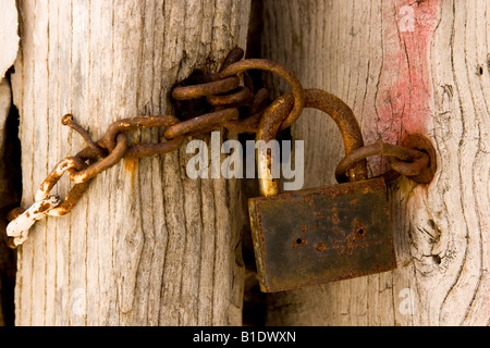Rusty padlock with chain hanging on old weathered door, Skopelos, Greece Stock Photo