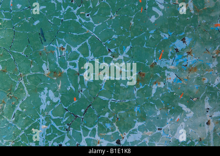Cracked and peeling bright green painted metal with blue colour showing through Stock Photo