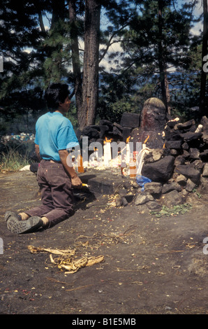Maya man making offerings in front of tha altar at the Shrine of Pascual Abaj in Chichicastenango, Quiché,Guatemala Stock Photo